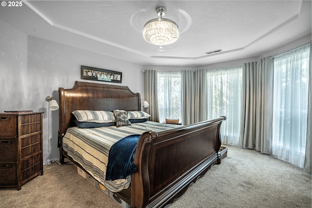 bedroom with a chandelier, a textured ceiling, visible vents, and light colored carpet