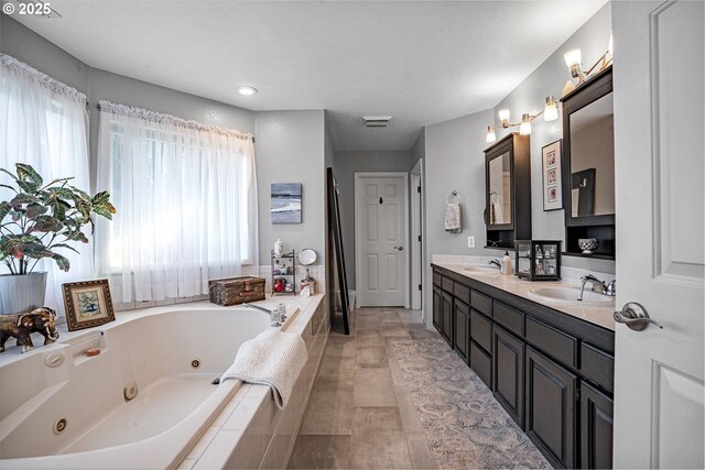 bathroom featuring vanity and tiled bath