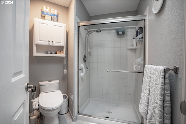 bathroom with toilet and a shower with shower door