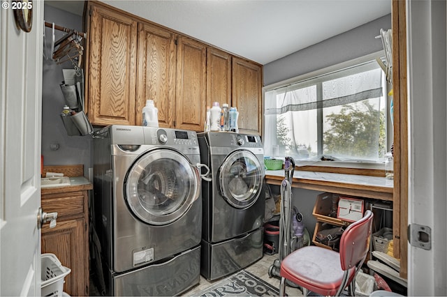 clothes washing area featuring cabinet space and washing machine and dryer