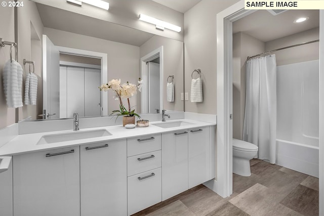 full bathroom featuring shower / bath combo with shower curtain, vanity, hardwood / wood-style flooring, and toilet