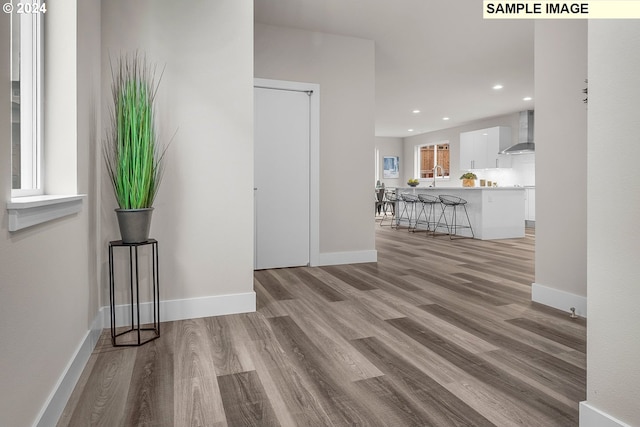 corridor with sink and light hardwood / wood-style flooring