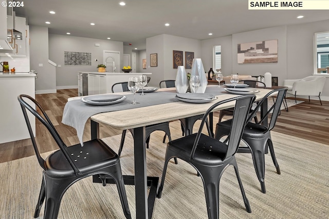 dining area with light wood-type flooring, a wealth of natural light, and sink