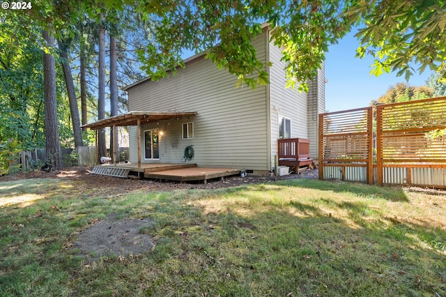 rear view of property with a wooden deck and a lawn