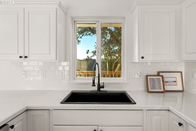 kitchen with white cabinets, tasteful backsplash, and sink