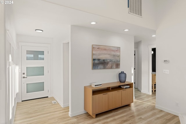 corridor with light hardwood / wood-style floors