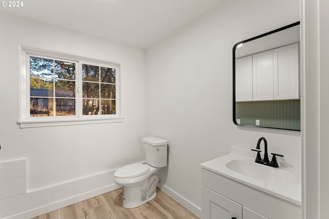 bathroom with toilet, vanity, and hardwood / wood-style floors