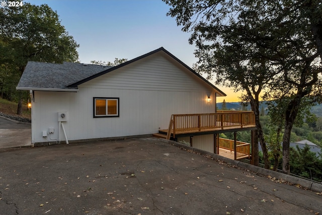 property exterior at dusk with a wooden deck