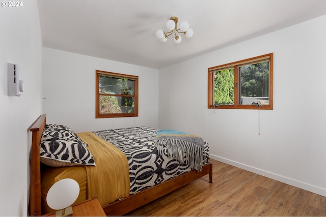 bedroom featuring a notable chandelier and light hardwood / wood-style floors