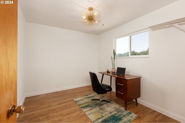 home office with an inviting chandelier and hardwood / wood-style flooring