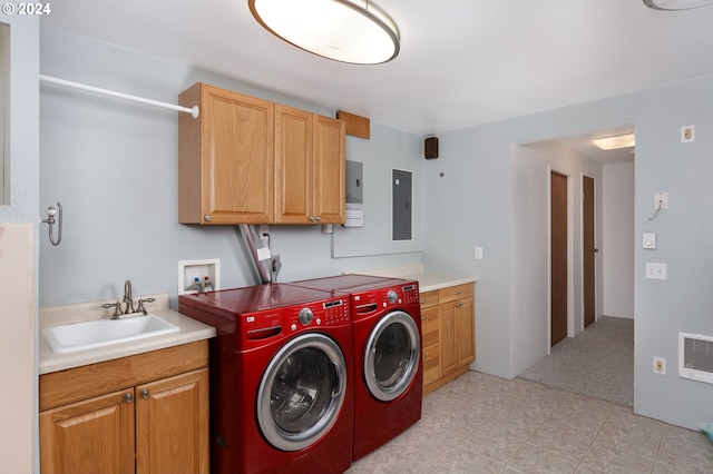 laundry area featuring electric panel, cabinets, separate washer and dryer, and sink