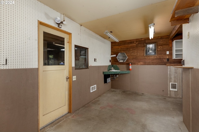 basement featuring wooden walls