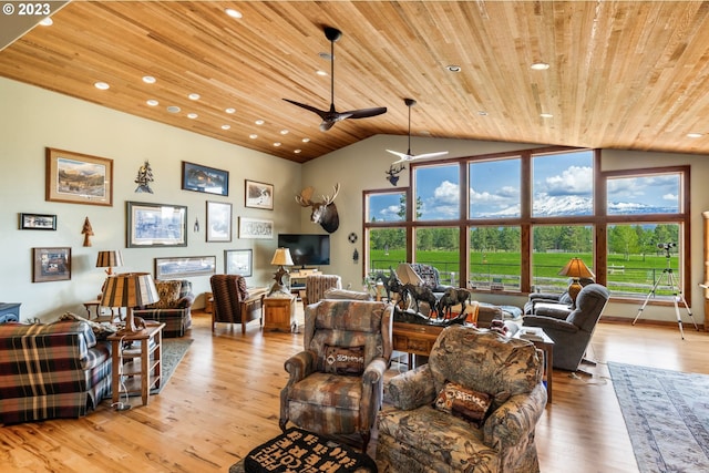 living room with ceiling fan, a high ceiling, light hardwood / wood-style floors, and wooden ceiling