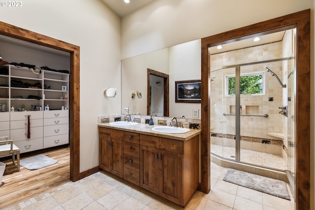 bathroom with tile flooring, double vanity, and an enclosed shower