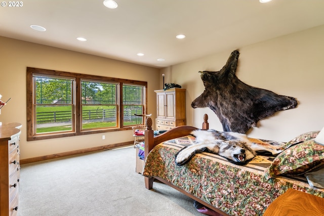 bedroom featuring light colored carpet and multiple windows