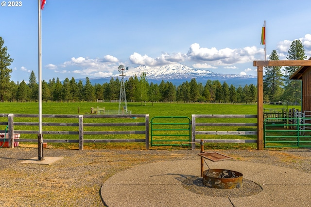 view of gate featuring an outdoor fire pit and a mountain view