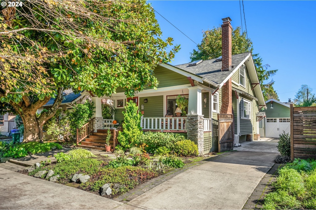 view of front of home featuring an outdoor structure, a porch, and a garage