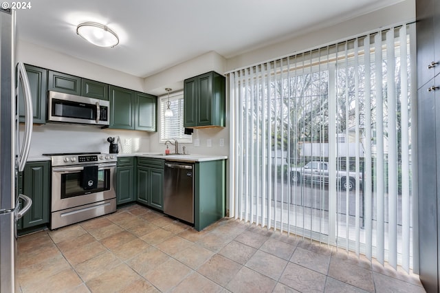 kitchen featuring sink, stainless steel appliances, light tile floors, and green cabinets