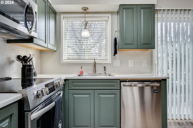 kitchen with a healthy amount of sunlight, hanging light fixtures, stainless steel appliances, and sink