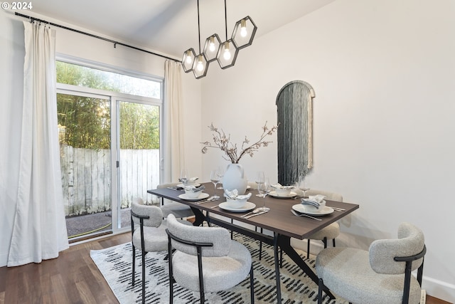 dining space with dark wood-type flooring and vaulted ceiling