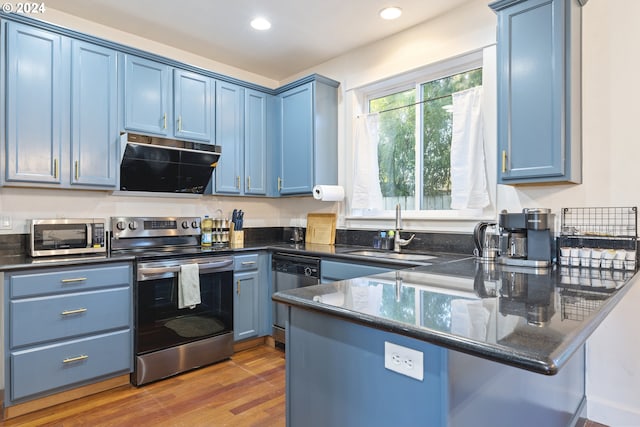 kitchen with dark wood-type flooring, sink, blue cabinetry, kitchen peninsula, and stainless steel appliances