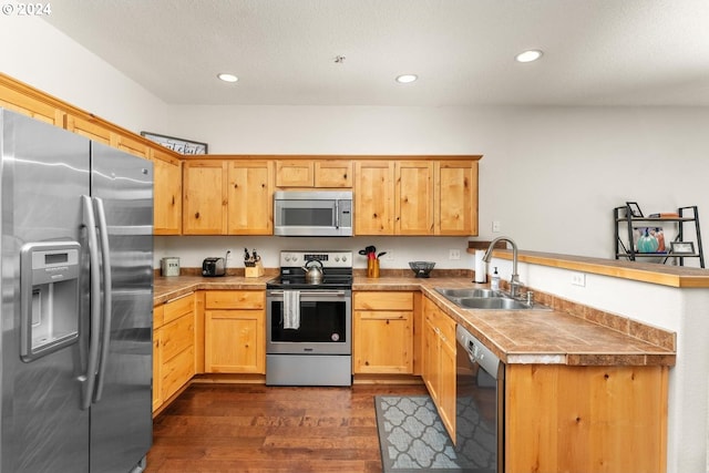 kitchen with dark hardwood / wood-style floors, tile counters, stainless steel appliances, sink, and kitchen peninsula