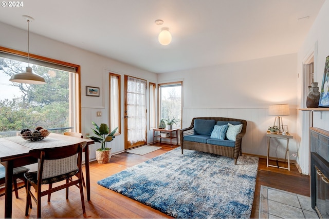 living room with a tiled fireplace and light wood-type flooring