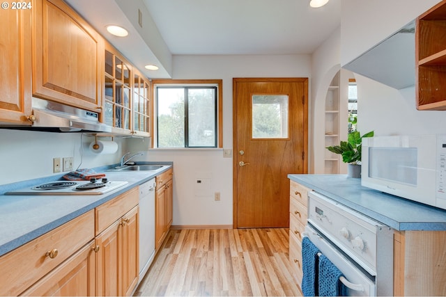 kitchen featuring range hood, sink, white appliances, and light hardwood / wood-style floors