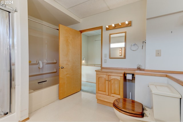 full bathroom featuring vanity, toilet, plus walk in shower, and a drop ceiling