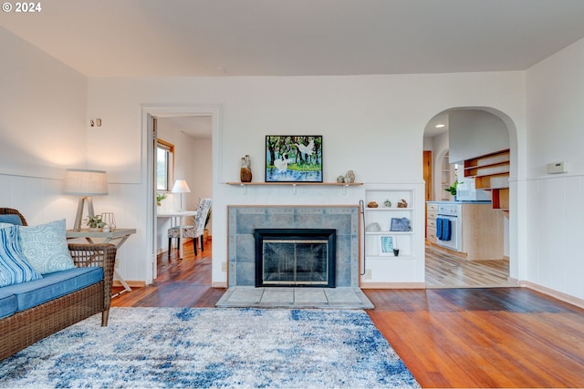 living room featuring a tile fireplace and hardwood / wood-style floors