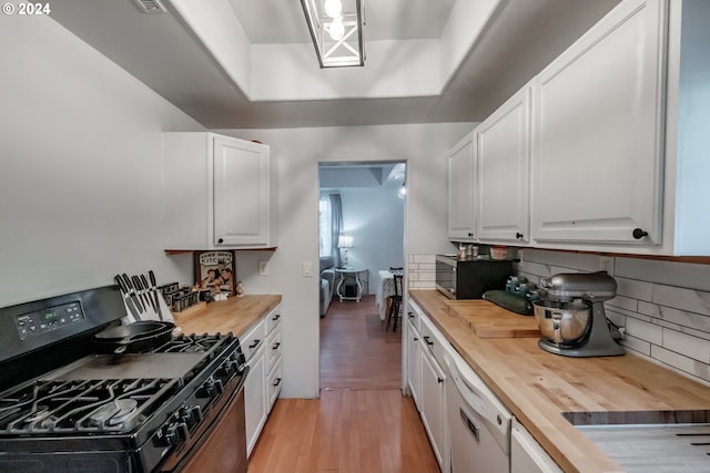 kitchen featuring light wood-style flooring, wood counters, white cabinets, and gas stove