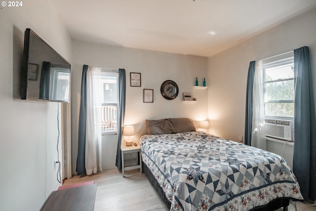 bedroom with light wood-style floors and cooling unit