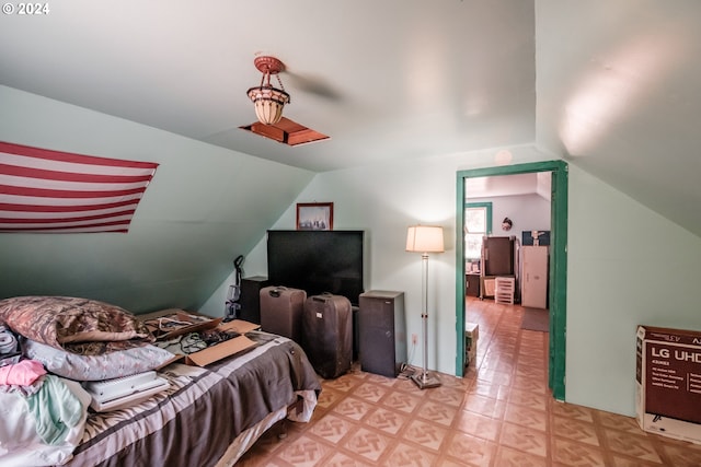 bedroom featuring light floors and vaulted ceiling