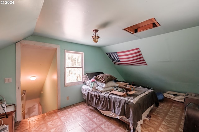 bedroom featuring lofted ceiling and attic access