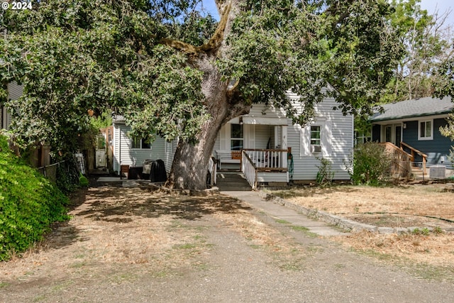 view of property hidden behind natural elements featuring fence and central air condition unit