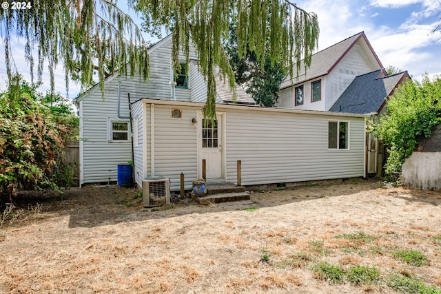 back of house featuring central air condition unit and fence