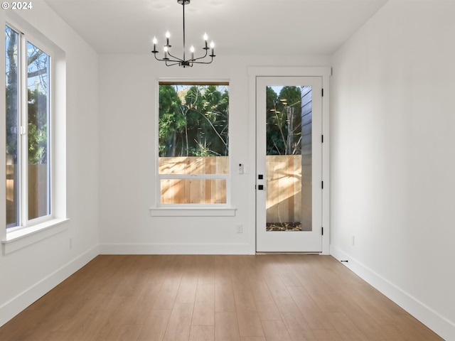 entryway featuring light hardwood / wood-style flooring, a chandelier, and plenty of natural light