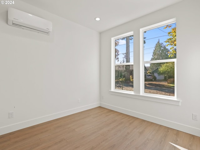 unfurnished room featuring light hardwood / wood-style floors and a wall mounted AC