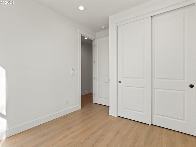 unfurnished bedroom featuring light hardwood / wood-style floors and a closet