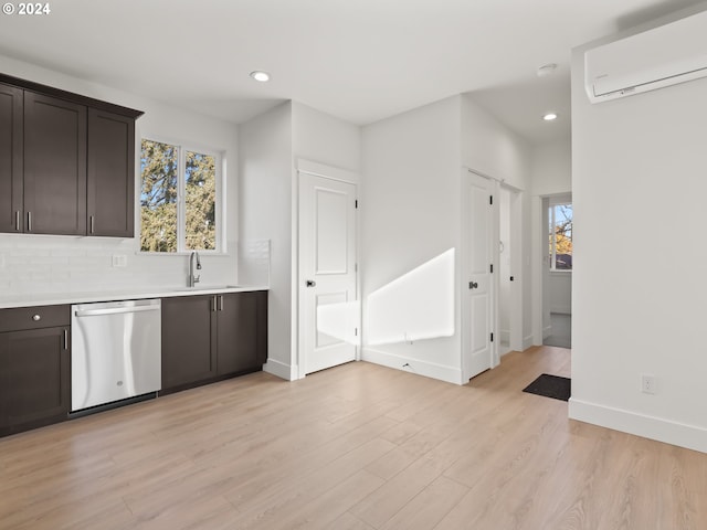 kitchen featuring dishwasher, dark brown cabinetry, a wall mounted AC, and light hardwood / wood-style flooring