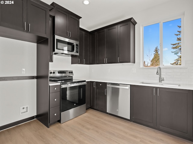 kitchen with stainless steel appliances, light hardwood / wood-style floors, and sink