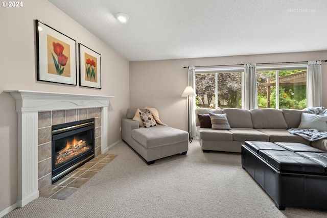 living room with carpet floors, a textured ceiling, and a tile fireplace