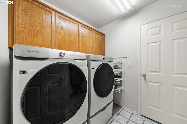 clothes washing area featuring cabinets and separate washer and dryer