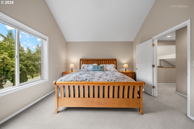 bedroom with light colored carpet and lofted ceiling