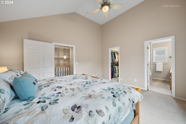 bedroom with vaulted ceiling, a spacious closet, a closet, ceiling fan, and ensuite bath