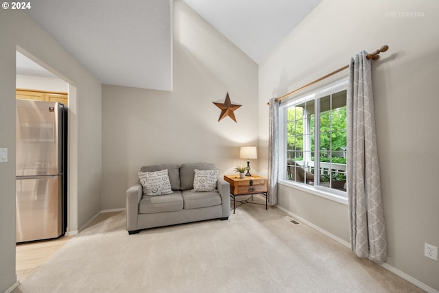 sitting room featuring lofted ceiling and light carpet