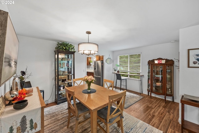 dining area with wood-type flooring and a notable chandelier