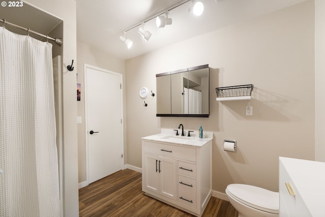 bathroom featuring vanity, hardwood / wood-style floors, toilet, and rail lighting