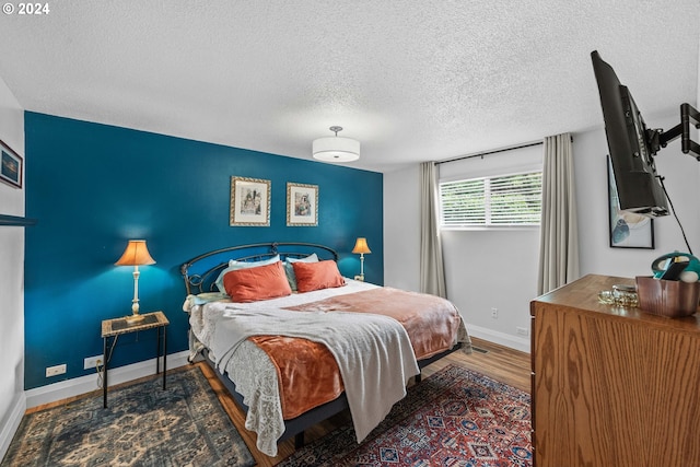 bedroom featuring hardwood / wood-style flooring and a textured ceiling