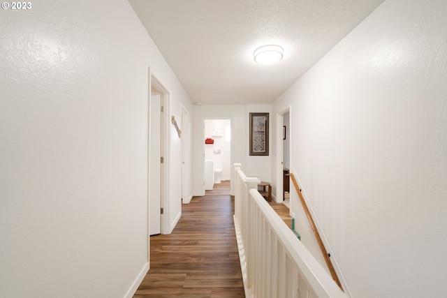 hallway featuring dark wood-type flooring and a textured ceiling